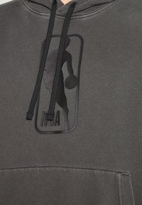 Kapuzensweatshirt aus dunkelgrauem Stoff. Mit einem schwarzen NBA-Logo und der Silhouette eines Basketballspielers. Die Kordeln sind schwarz.