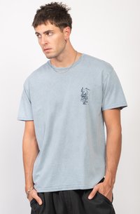 Camiseta de algodón azul claro con un diseño de mangas cortas y un pequeño gráfico de un pájaro azul oscuro en el lado izquierdo del pecho.
