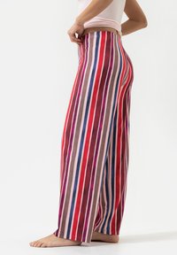 Pantalons larges à rayures avec un mélange de couleurs rouge, rose, violet et marron, fabriqués dans un tissu doux et léger avec une taille élastique.
