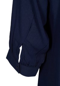Chemise bleu marine à manches longues avec détail de tissu froncé et poignet boutonné.