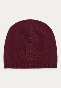 Burgundijas adīta cepure ar reljefu logotipu. Gluda tekstūra un pieguloša forma, kas piemērota vēsākam laikam.