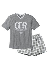 Graues Baumwoll-T-Shirt mit V-Ausschnitt und weißen Akzenten, mit grafischem Druck auf der Vorderseite. Kombiniert mit karierter Boxershorts in Grau und Weiß.