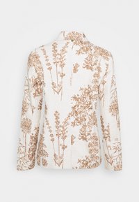 Veste florale blanche arborant des motifs botaniques marron complexes, manches longues, col, et tissu texturé. Vue de dos montrant l'impression détaillée.