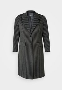 Črn plašč z bħalčnim vzorcem, ki ima izrezan ovratnik, dve sprednji žepi in en gumb za zapiranje. Material se zdi strukturiran s gladko površino.