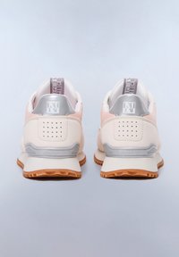 Baskets beige avec une tige lisse, accents argentés, semelle texturée et perforations au niveau du talon. Logo affiché sur le talon et la languette.