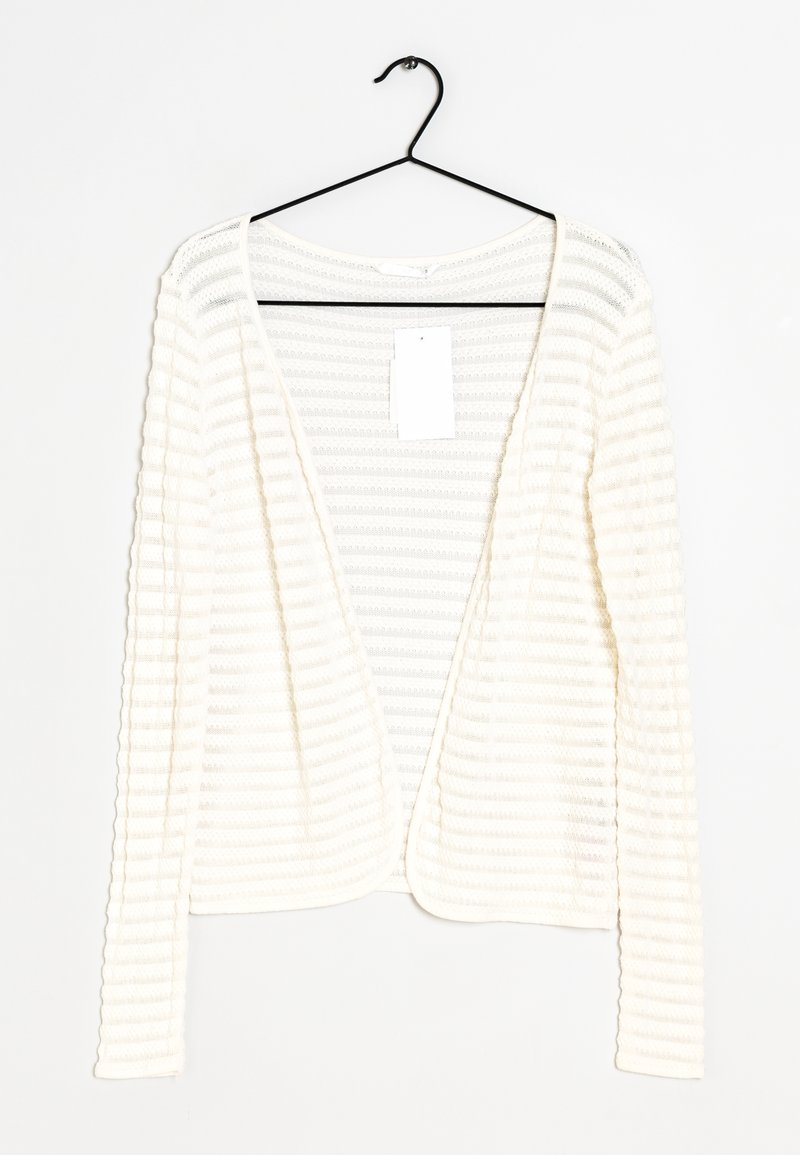 Biała, prążkowana kardigan z długim rękawem i otwartym przodem, wiszący na czarnym haczyku. Metka przymocowana wewnątrz dekoltu. Miękka tekstura.