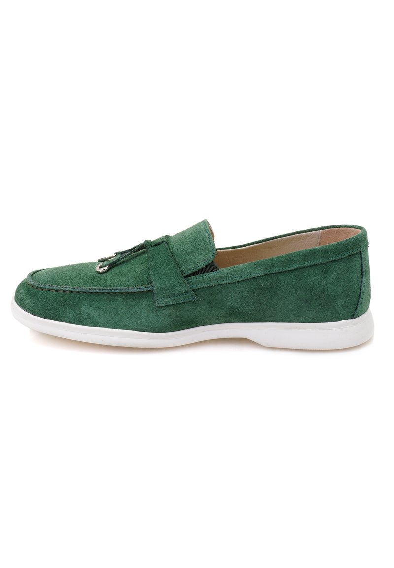 Green suede loafer with a white sole, featuring a rounded toe, stitching detail, and a decorative leather strap across the vamp.