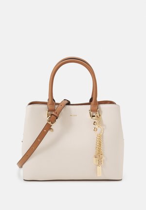Sac à main beige avec une finition texturée, poignées en cuir marron, une bandoulière détachable, des accents en matériel doré et une chaîne décorative avec des pendentifs.