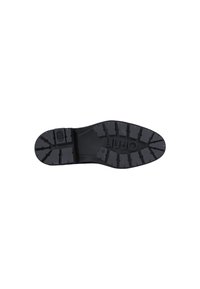 Semelle de chaussure en caoutchouc noir avec un motif de semelle distinctif, comportant des sections moulées pour une meilleure adhérence. Logo de marque imprimé près de la zone du talon.