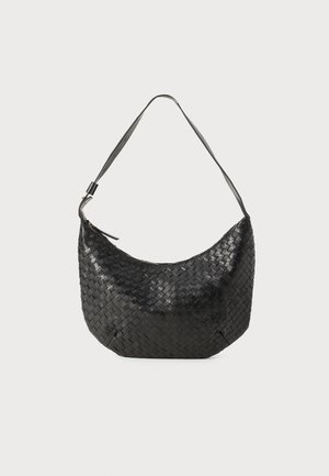 Woven black leather handbag with a curved shape, single shoulder strap, and zipper closure. Textured finish adds depth to the design.