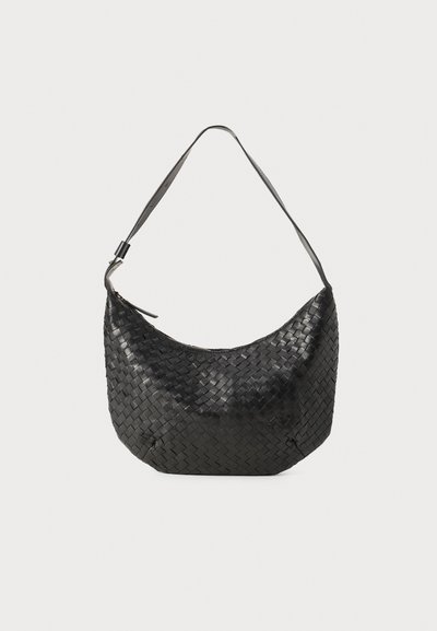 Bolso de mano de cuero negro trenzado con forma curva, correa para el hombro única y cierre de cremallera. El acabado texturizado añade profundidad al diseño.