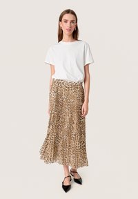 Plisseret midiskørt i leopardprint med en beige og brun farvepalet, parret med en hvid t-shirt med rund hals og sorte spidse sko.