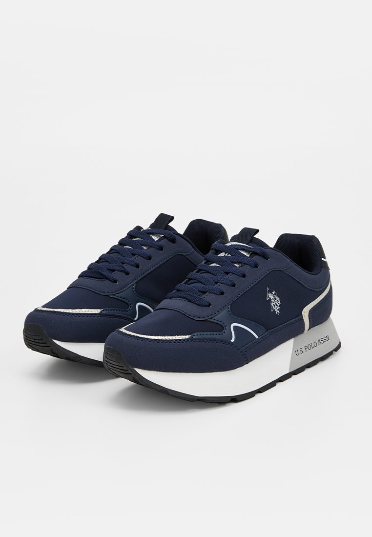 Zapatillas azul marino con una mezcla de tela y material sintético, con una entresuela blanca, diseño de cordones y detalle del logo en el lateral.