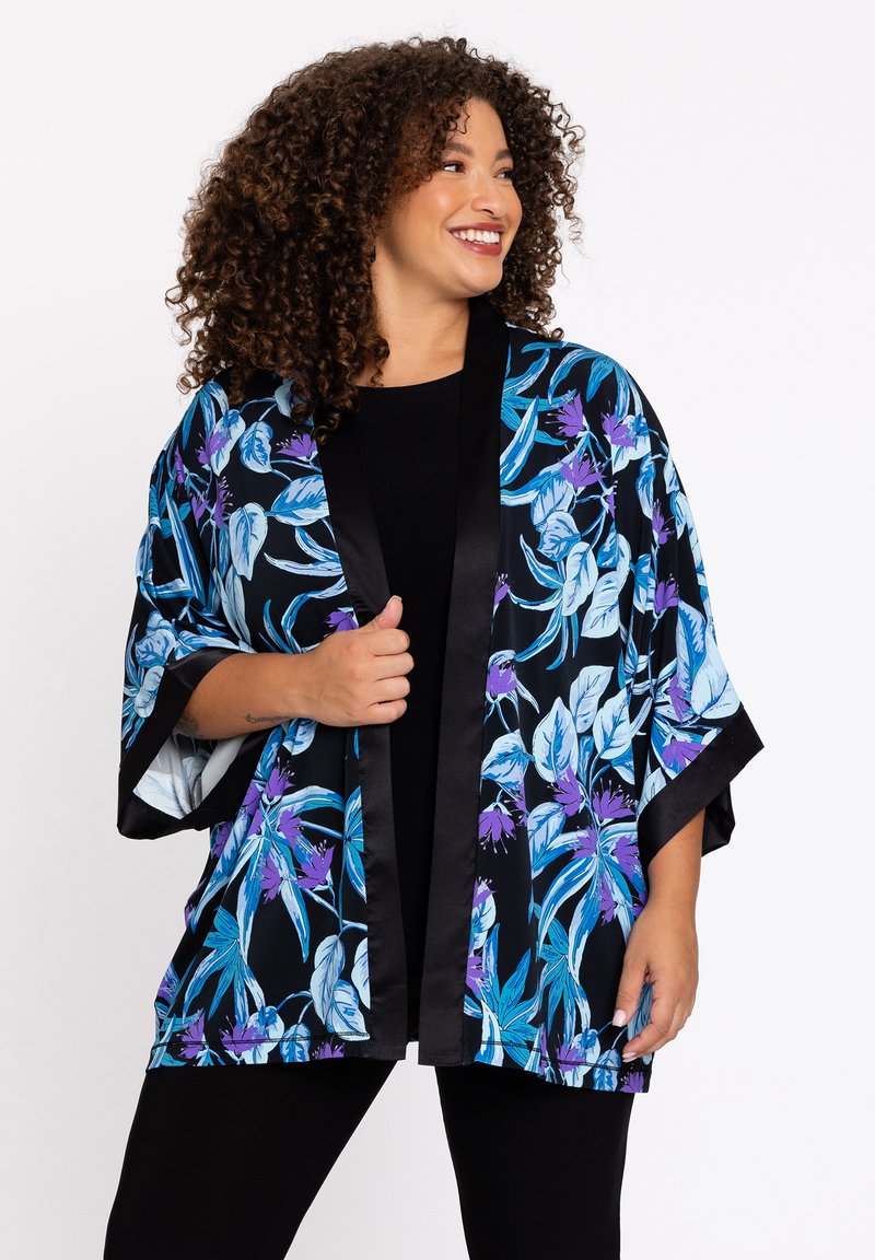 Bloemen kimono met opvallende blauwe en paarse bladpatronen op een zwarte achtergrond. Satijnen afwerking, losse mouwen en zwarte bies langs de randen.