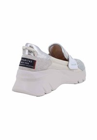 Sneaker argentata senza lacci con una tomaia testurizzata, suola chunky bianca e un'etichetta con cuciture rosse. Il retro presenta un accento metallico.