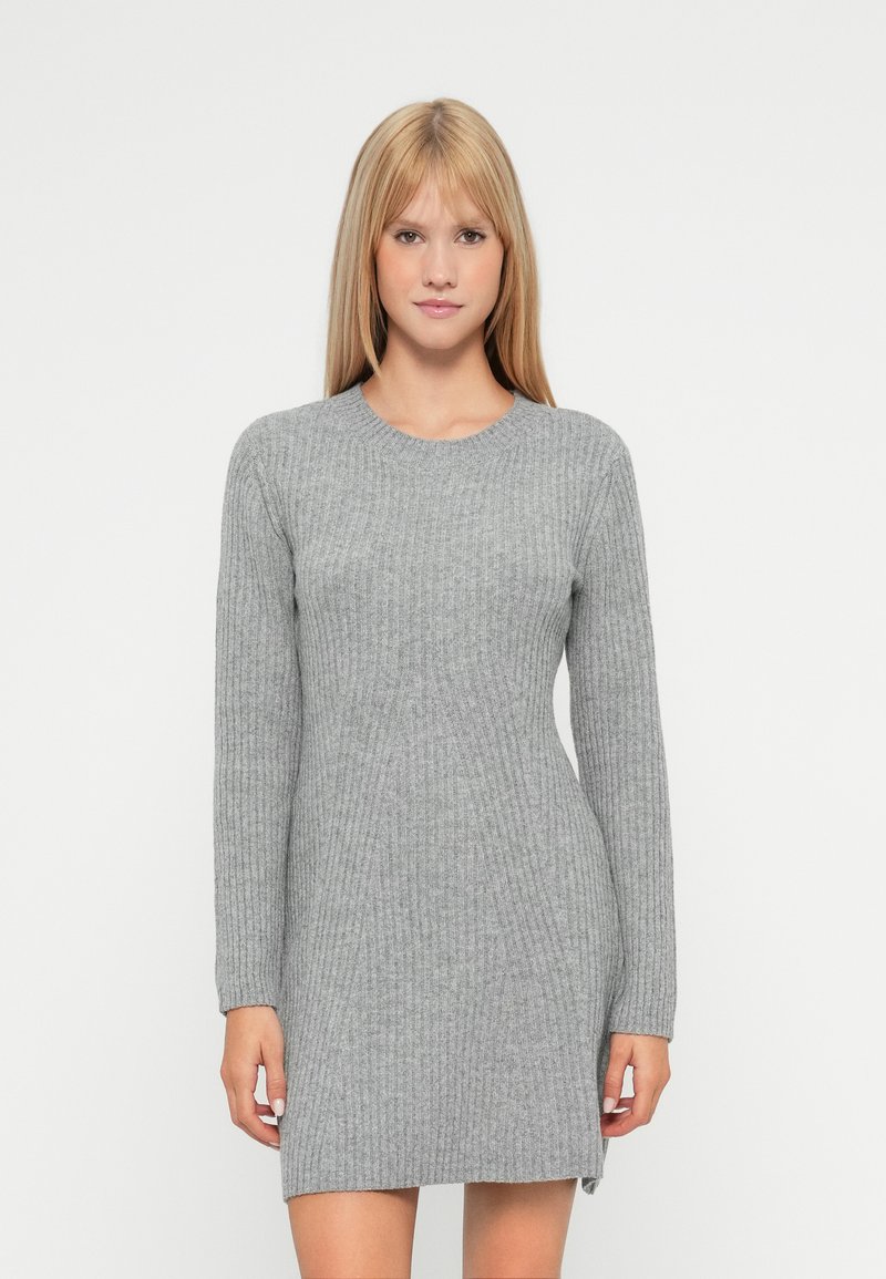 Grå ribbestrikket kjole med lange ermer, rund hals og sidespalter. Myk tekstur og tettsittende design, perfekt for ulike anledninger.