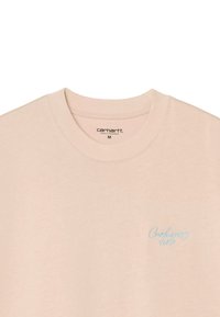 T-shirt in cotone beige chiaro con collo rotondo, caratterizzata da un piccolo logo blu ricamato nell'area sinistra del petto. Texture morbida, peso medio.