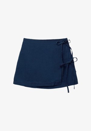 Jupe enveloppante bleu marine en tissu léger avec une texture douce. Présente une fermeture à nouer sur le côté et un ourlet qui se courbe délicatement.