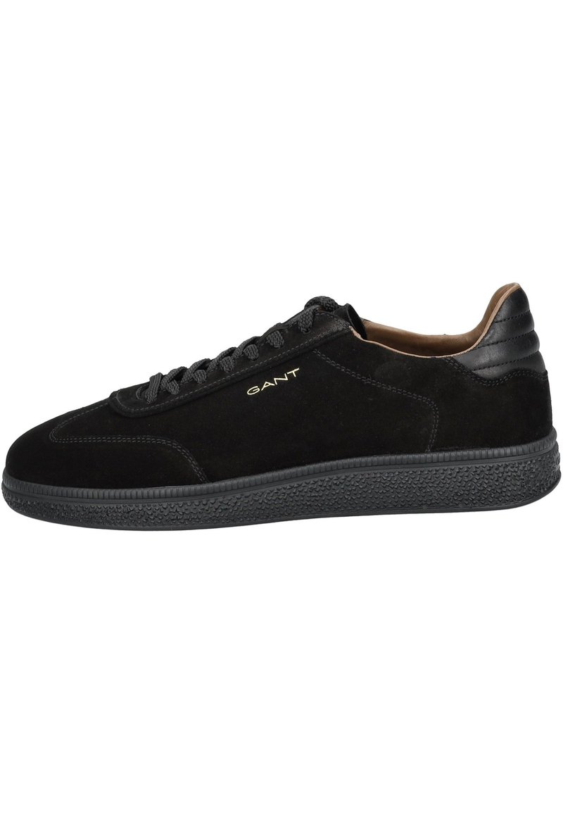Black suede sneakers with a textured rubber sole, round toe, and black laces. Features a gold logo on the side and a smooth leather heel cap.