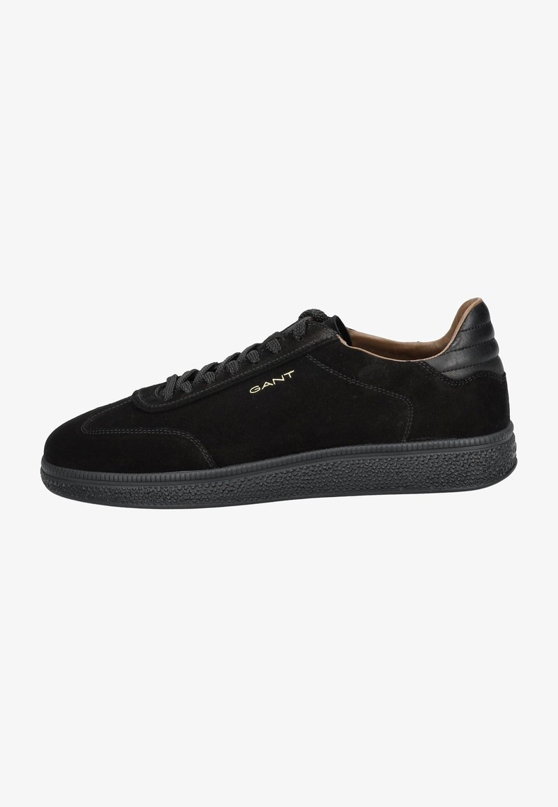 Black suede sneakers with a textured rubber sole, round toe, and black laces. Features a gold logo on the side and a smooth leather heel cap.