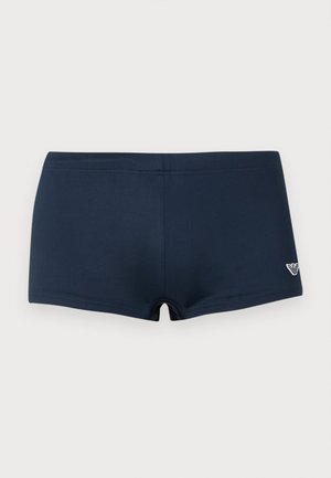 Donkerblauwe heren zwemshort met een klein wit logo aan de voorkant rechts, plat liggend tegen een effen achtergrond.