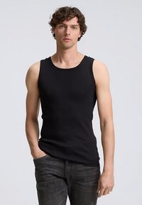 Svart ärmlös linne i ett mjukt, stretchigt material med rund halsringning och figurnära passform. Matchas med mörka jeans.