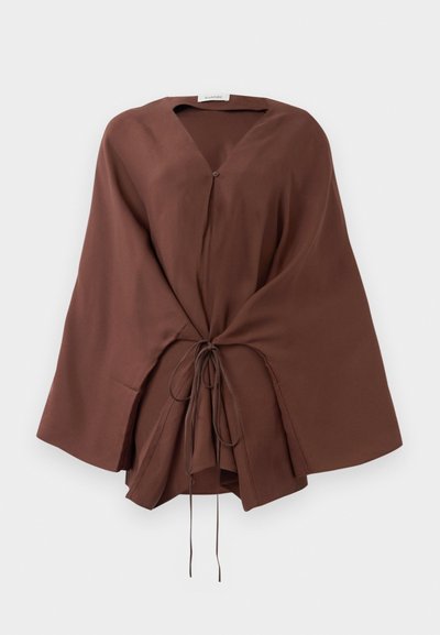 Pruun V-kaelusega ülepanev jakk laia varrukaga ja eesriide detailidega, lõdva istuvusega, esitleb valgel taustal.