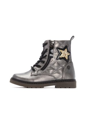 Botas de tobillo metálicas plateadas con un diseño acolchado, cordones negros, cremallera lateral y un acento de estrella de purpurina dorada en el lado exterior.