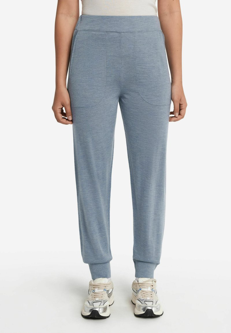 Ljusblå joggerbyxor med elastisk midja, sidofickor och avsmalnande ärmar. Tillverkade av ett mjukt tyg med en slät textur och minimal sömnad.