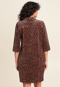Bruine corduroy jurk met een luipaardprint; heeft driekwartmouwen en een kraag; rechte snit en knie-lange ontwerp.