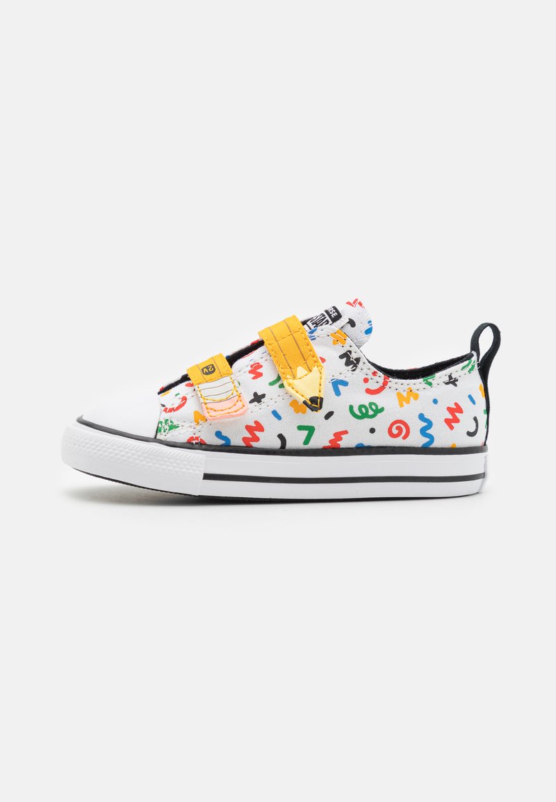 Canvas sneakers with a white base, colorful abstract patterns, yellow Velcro straps, and black and white striped sole.