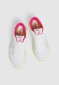 Witte sportschoenen met roze accenten rond de kraag, groene buitenzool en bovenwerk van textuurstof. Beschikt over veters en logodetails op de tong.