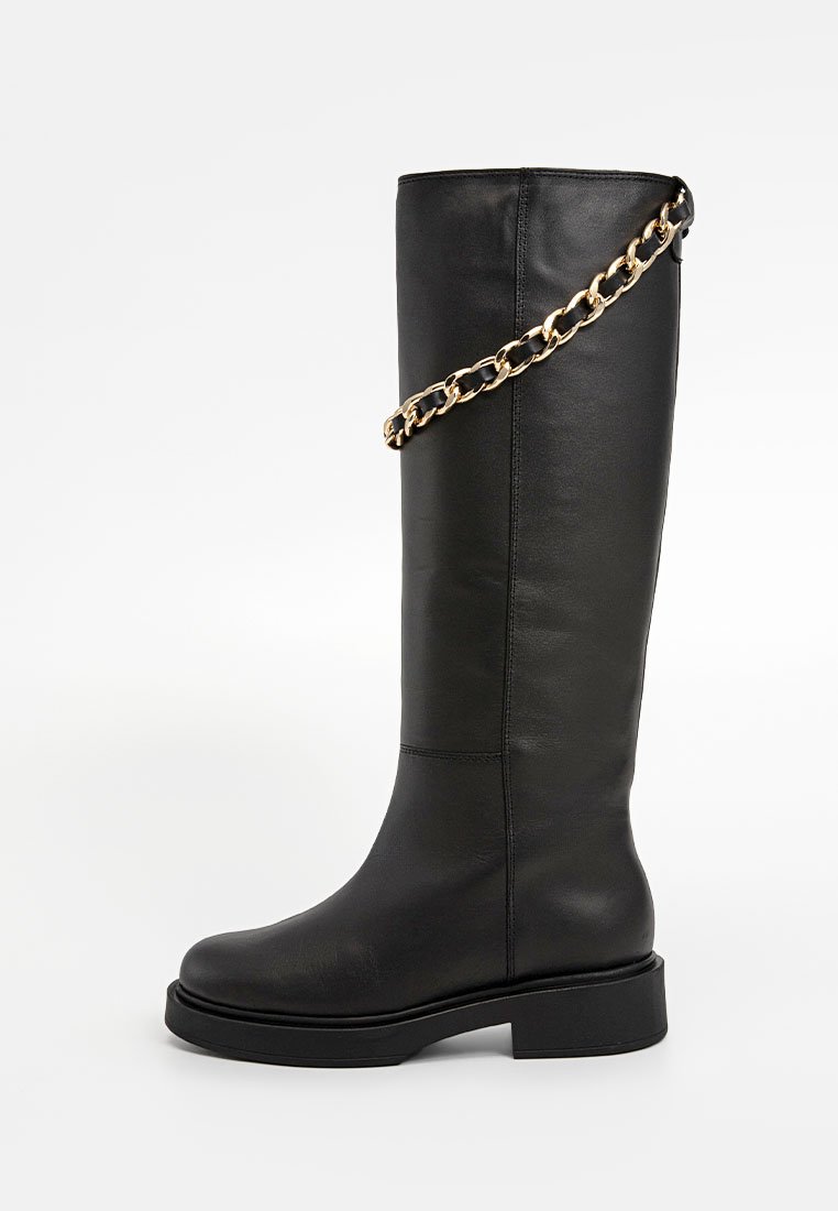 Schwarze kniehohe Lederstiefel mit klobiger Sohle und goldener Kettendetail um den oberen Schaft, vor einem weißen Hintergrund gezeigt.