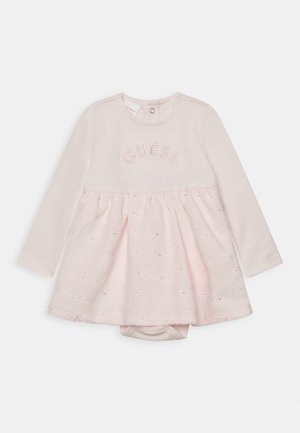 Robe rose clair à manches longues, avec broderie "GUESS" sur la poitrine et une jupe à motifs floraux. Fermeture à pression au dos.