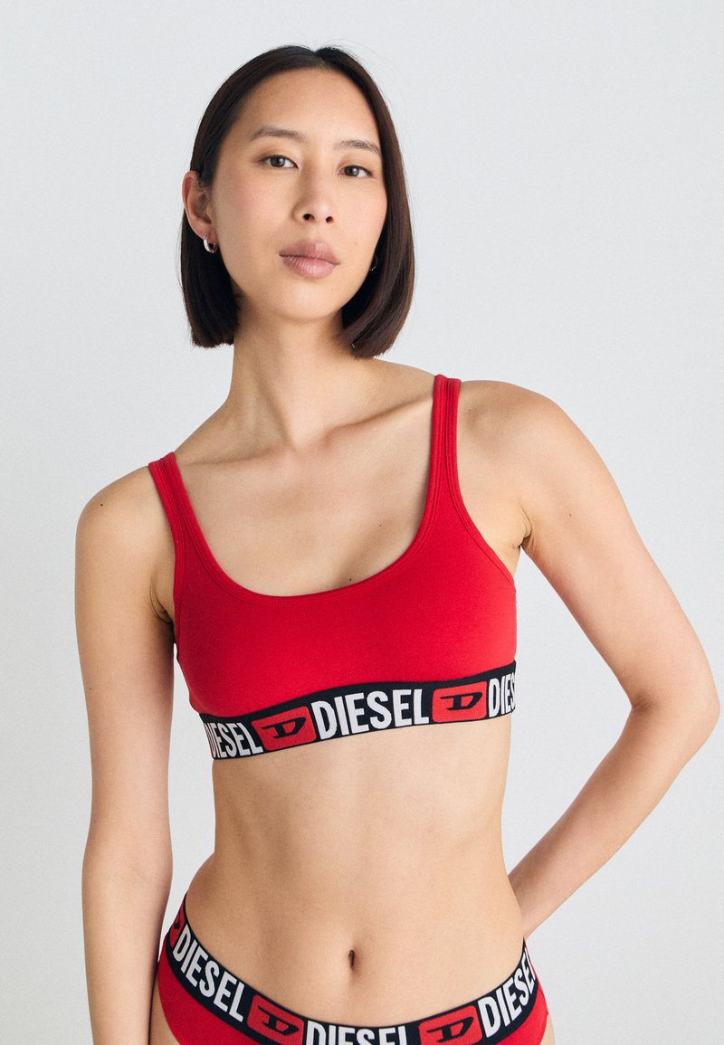 Rdeča bombažna bralette s tankimi naramnicami, s črnimi trakovi z logotipom "DIESEL". Gladka tekstura in prilegajoča zasnova.