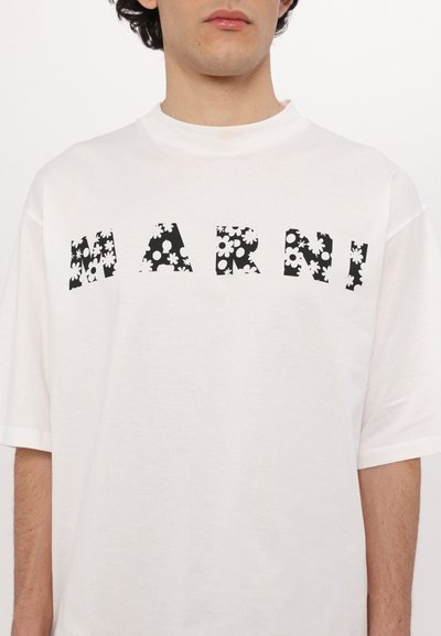 White cotton t-shirt with short sleeves featuring the word "MARNI" in black floral print. Crew neckline, relaxed fit, and minimalistic design.