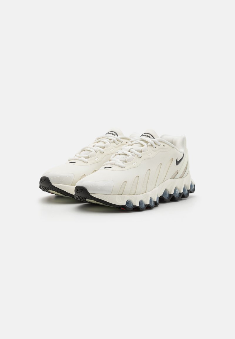 Weiße Sportschuhe mit strukturiertem Synthetik-Obermaterial, schwarzen Akzenten an der Zehe und dem Logo sowie einer markanten, gepolsterten Sohle mit abgerundeten Pods.