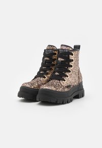 Botas de tobillo gruesas con una base negra y una parte superior brillante en rosa y dorado. Presentan cordones negros y herrajes dorados para mayor refuerzo.