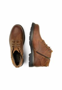 Bruine leren enkelboots met een gestructureerde afwerking, vetersluiting aan de voorkant, zijrits en robuuste zwarte rubberen zolen voor grip.