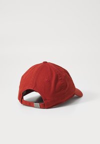 Piros pamut baseball sapka ívelt karimával, hátul állítható pánttal és tónusosan varrva. Simaszerkezetű, nem látható mintákkal.