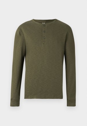 Garais piedurkņu olīvzaļais henley krekls ar apaļu kakla izgriezumu, trim pogām apkaklīte un teksturētu auduma apdari.