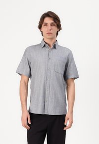 Chemise à manches courtes, à boutons, de couleur grise avec une texture subtile. Dotée d'une poche poitrine avec un accent bleu et des fermetures à boutons.