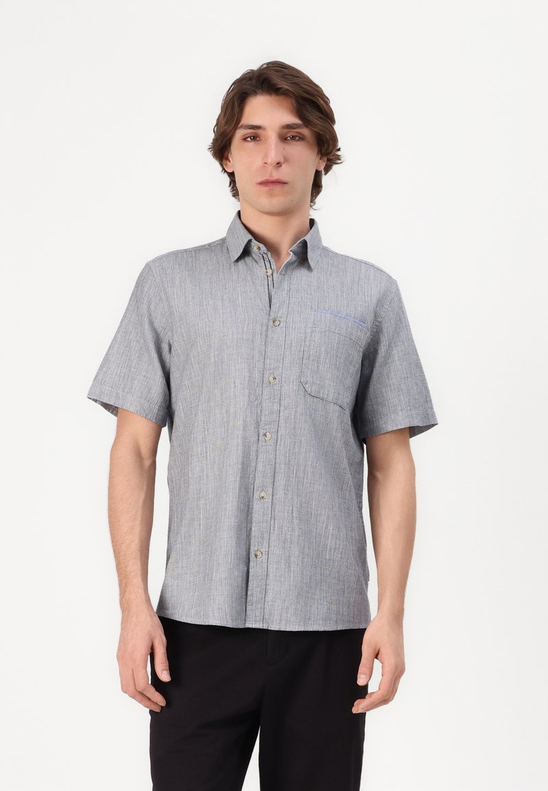 Chemise à manches courtes, à boutons, de couleur grise avec une texture subtile. Dotée d'une poche poitrine avec un accent bleu et des fermetures à boutons.
