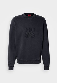 Sudadera negra de cuello redondo, con puños y dobladillo acanalados. Presenta un logotipo texturizado "HUGO" en la parte delantera. Fabricada en un tejido suave.
