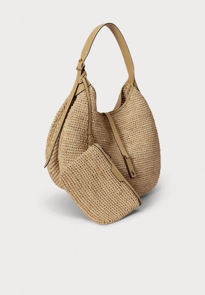 Τσάντα ώμου από μπεζ πλεκτό άχυρο με μικρό τσαντάκι σε ταιριαστό χρώμα, λεπτομέρειες από ταμπά δέρμα και ρυθμιζόμενο ιμάντα ώμου σε λευκό φόντο.