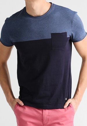 Herret-shirt med korte ærmer, der har en blå tekstureret øverste del og en ensfarvet marineblå nederste del, med en brystlomme og et enkelt design.