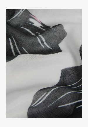 Țesătură ușoară cu un model floral negru pe un fundal alb, având texturi variate și un efect de drapare moale.