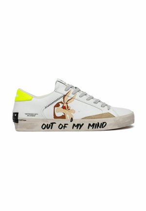 Scarpa da ginnastica bianca con tacco giallo, personaggio dei cartoni animati Wile E. Coyote e la frase "Out of my mind" scritta sulla suola con lettere nere.