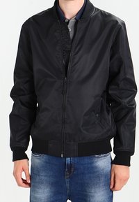 Svart bomberjacka tillverkad av slät, lättviktsmaterial; har dragkedja framtill, ribbade ärmslut och midja, samt en klassisk krage.