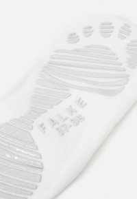 Calzino bianco con suola testurizzata caratterizzata da linee di presa e punti; stampato "FALKE 37-38" in grigio. Tessuto morbido e design flessibile.